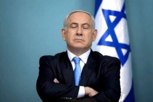 Netanyahu con gli occhi chiusi davanti alla bandiera Israeliana